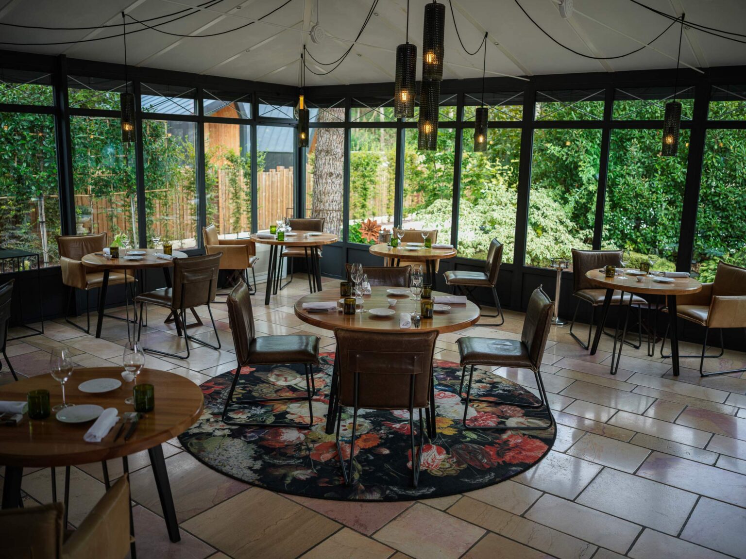 La salle du restaurant du Verbois, verrière ouverte sur le jardin